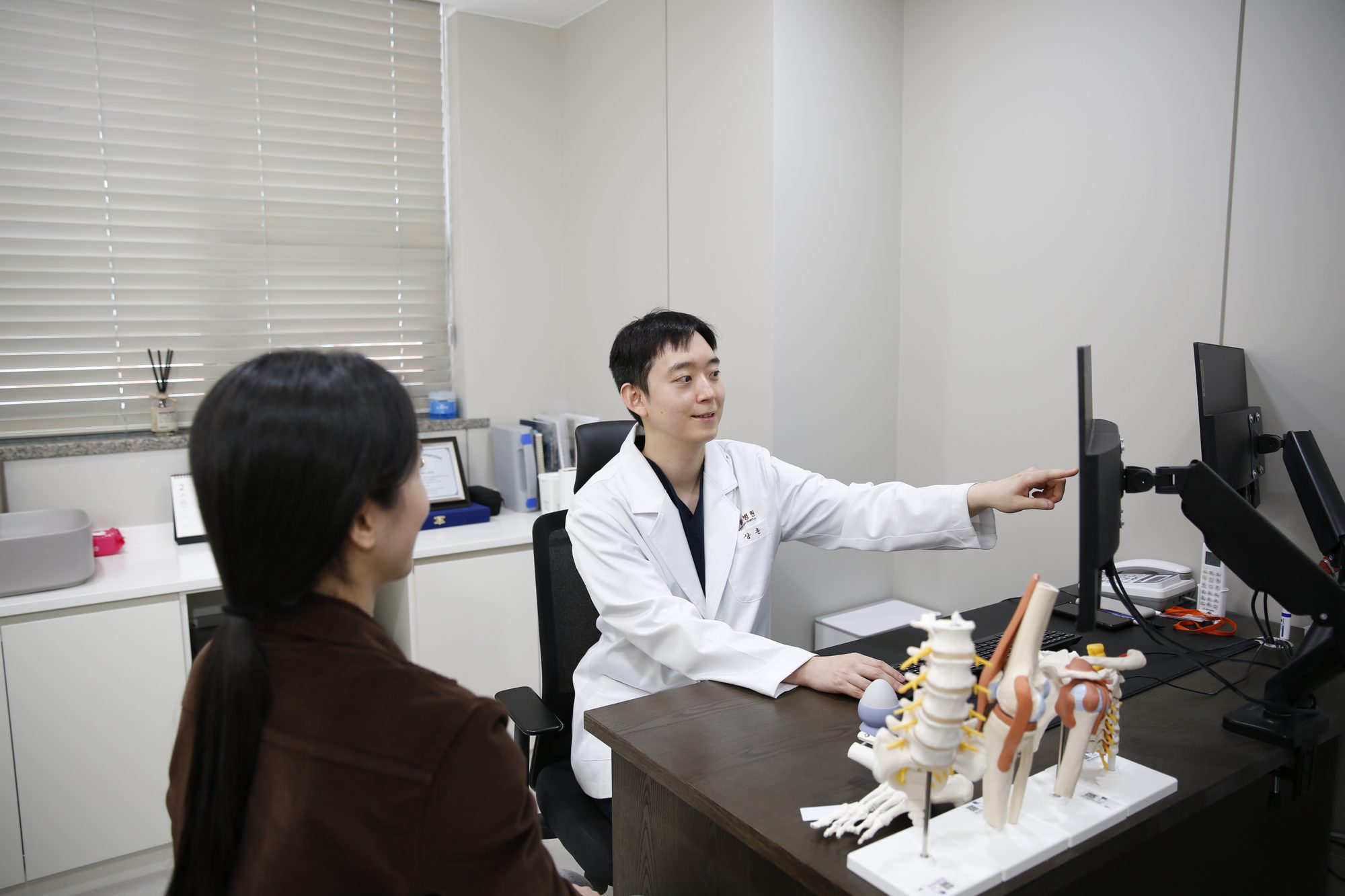 Rehabilitation physician consulting with a spine model